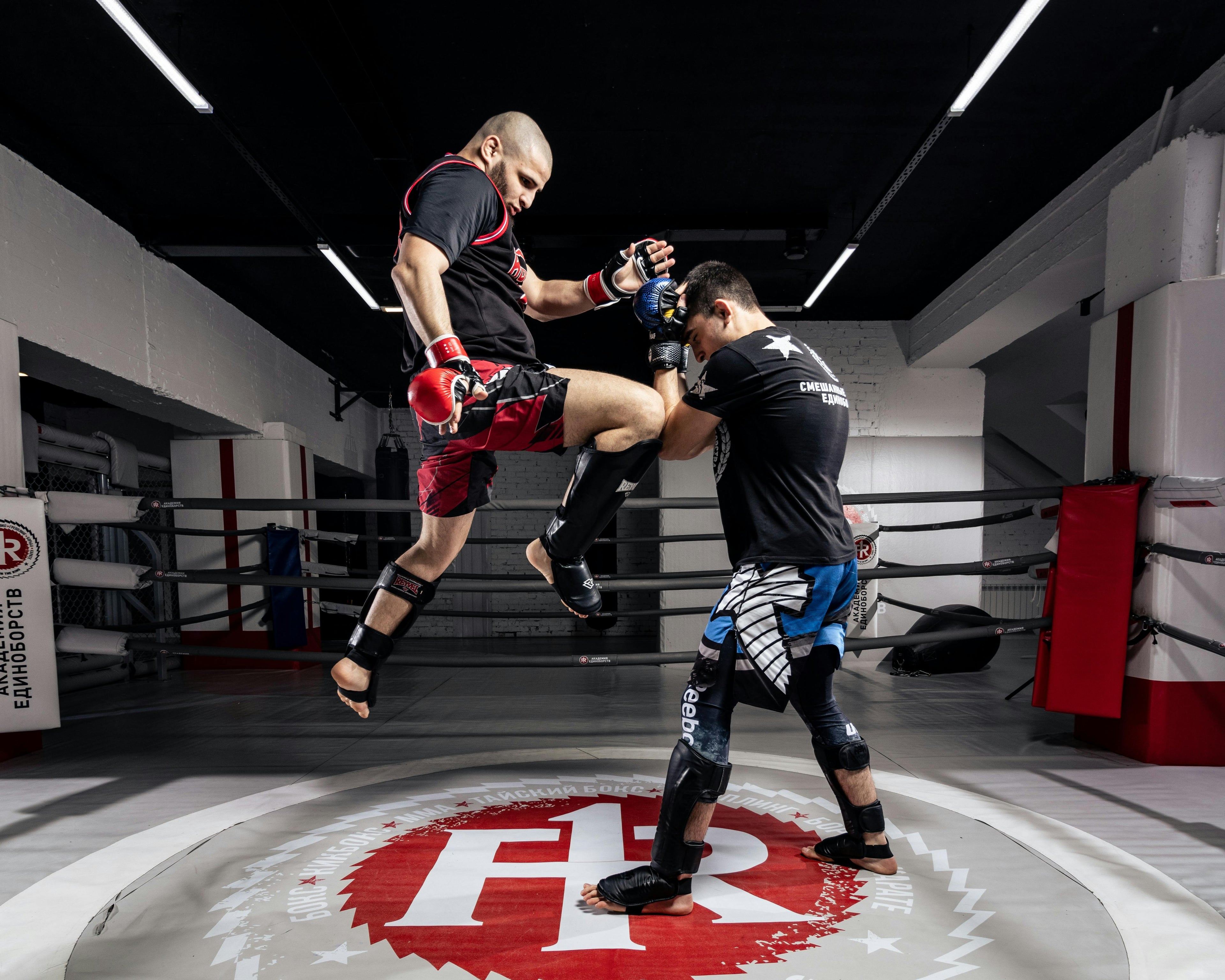 Two individuals practicing martial arts in a gym