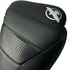 Close-up of a black boxing glove featuring a white stylized winged logo on the upper cuff and a textured honeycomb-patterned panel on the side, set against a plain white background.