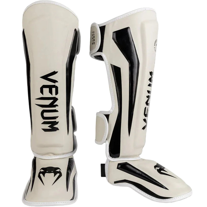 Pair of Venum shin guards on a gray background