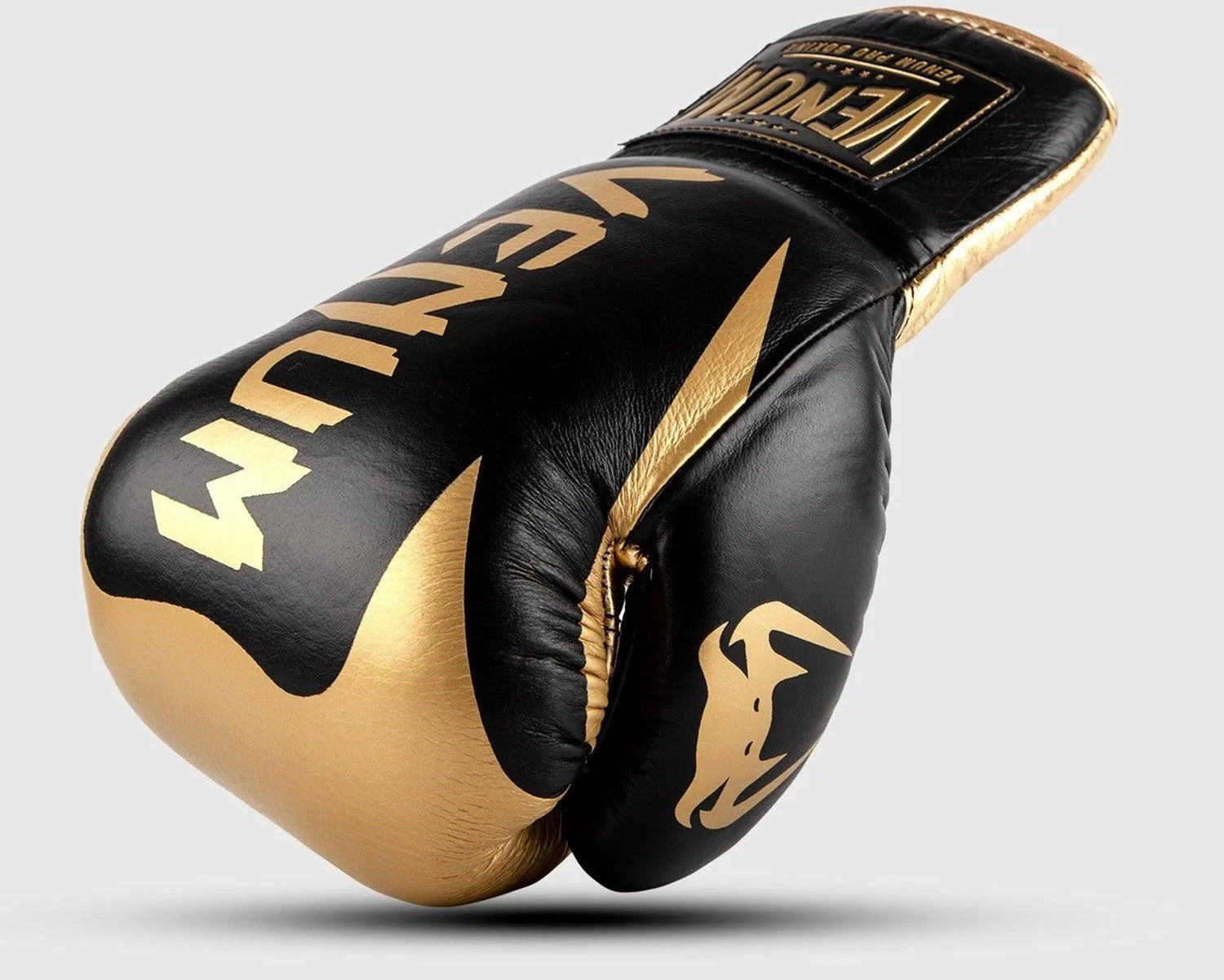 Black and gold boxing gloves with 'Venum' branding on a lightGold background