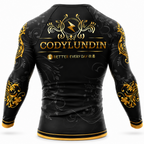Black long-sleeve athletic rash guard with gold and gray decorative graphics, featuring the name 'CODYLUNDIN' and the phrase 'BETTER EVERY DAY' on the back, shown on a white background.