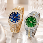 Two luxury wristwatches with diamond-encrusted metal bands and Roman numeral dials, one gold-tone with a blue dial and one silver-tone with a green dial, displayed on a marble surface with a blurred glass background.