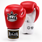 A pair of red boxing gloves with white interiors and white hand wraps featuring the black and gold RAJA Boxing logo, photographed on a clean white background.