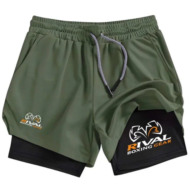 Green athletic shorts with a black patch featuring 'Rival Boxing Gear' on a white background.