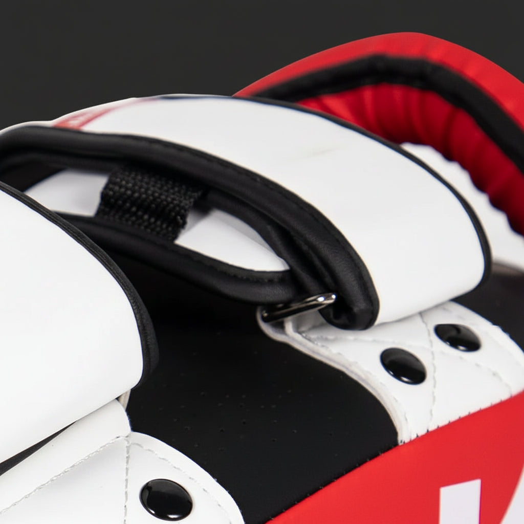 Close-up of a sports equipment, possibly a glove or protective gear, with red, white, and black colors.