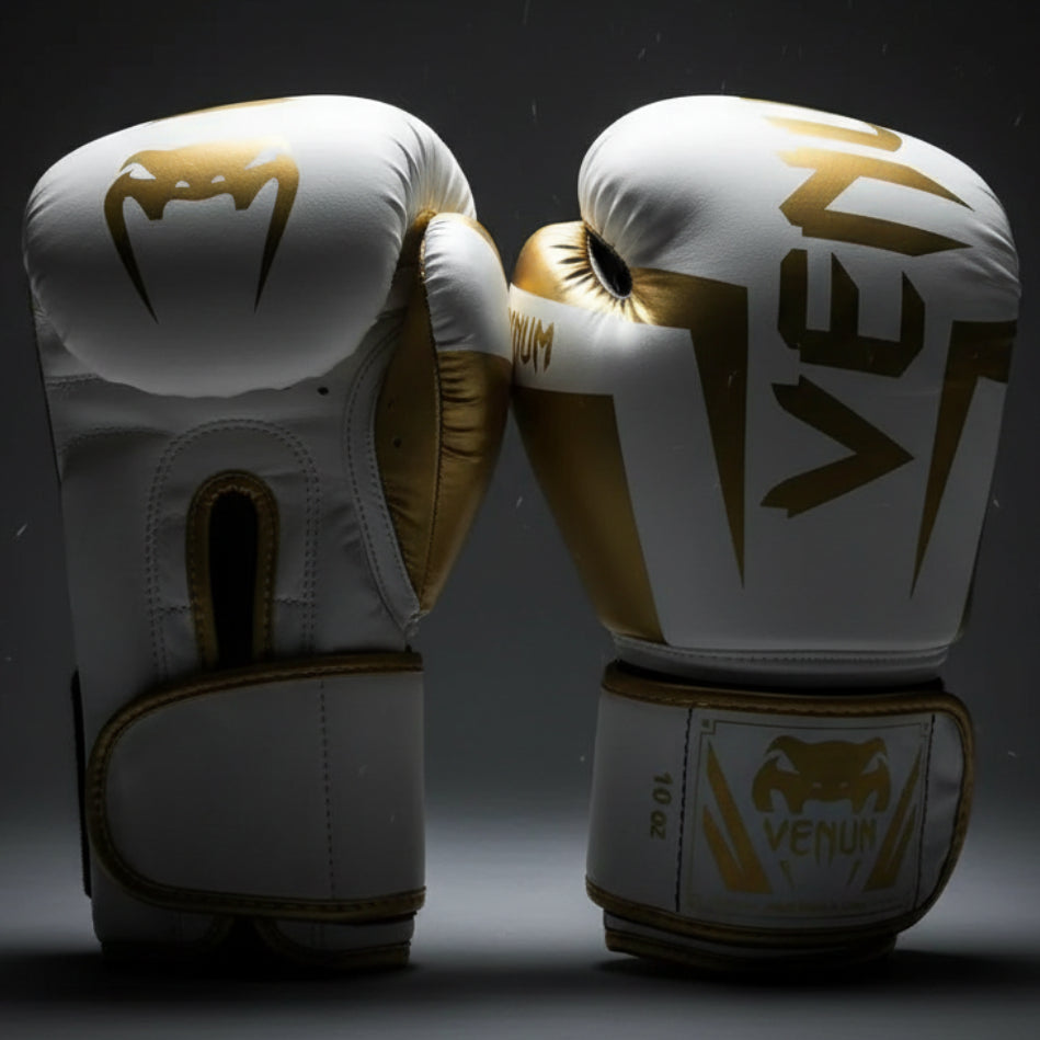 Pair of white boxing gloves with gold accents and Venum branding on a white background