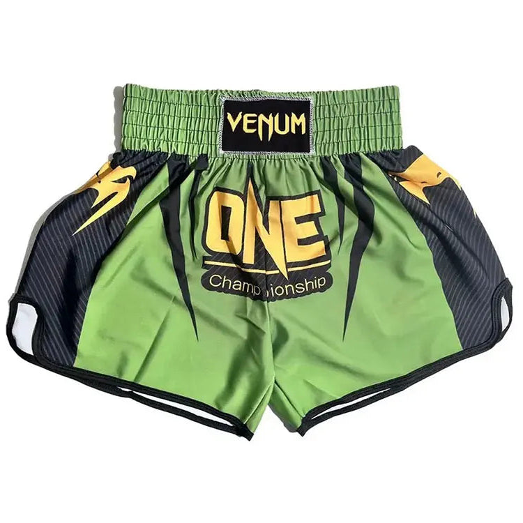 Green and black Venum Muay Thai shorts with a yellow 'ONE Championship' logo on the front, displayed flat against a white background.