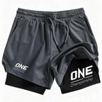 Black athletic shorts with a white 'ONE Championship' logo on the left leg and a black inner layer visible at the hem, shown on a plain white background.