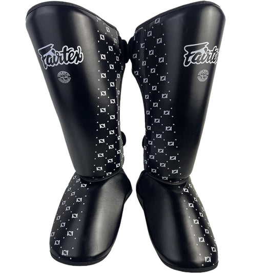 Pair of black Fairtex shin guards with white pattern and 'Fairtex' branding on a white background