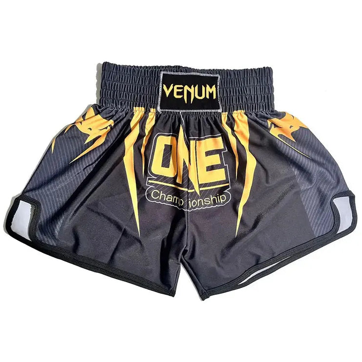 Black and yellow Venum Muay Thai shorts with 'ONE Championship' graphics on the front, displayed flat against a white background.