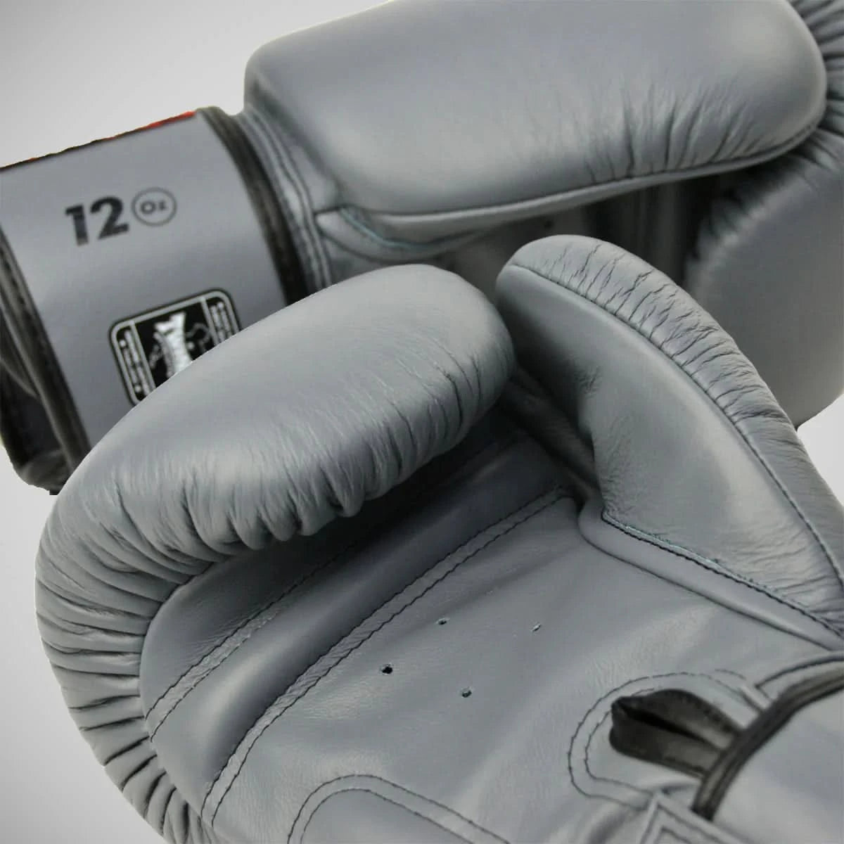 Gray boxing gloves with '12 oz' label on a light gray background