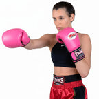 Woman wearing black boxing gloves with visible branding on a white background