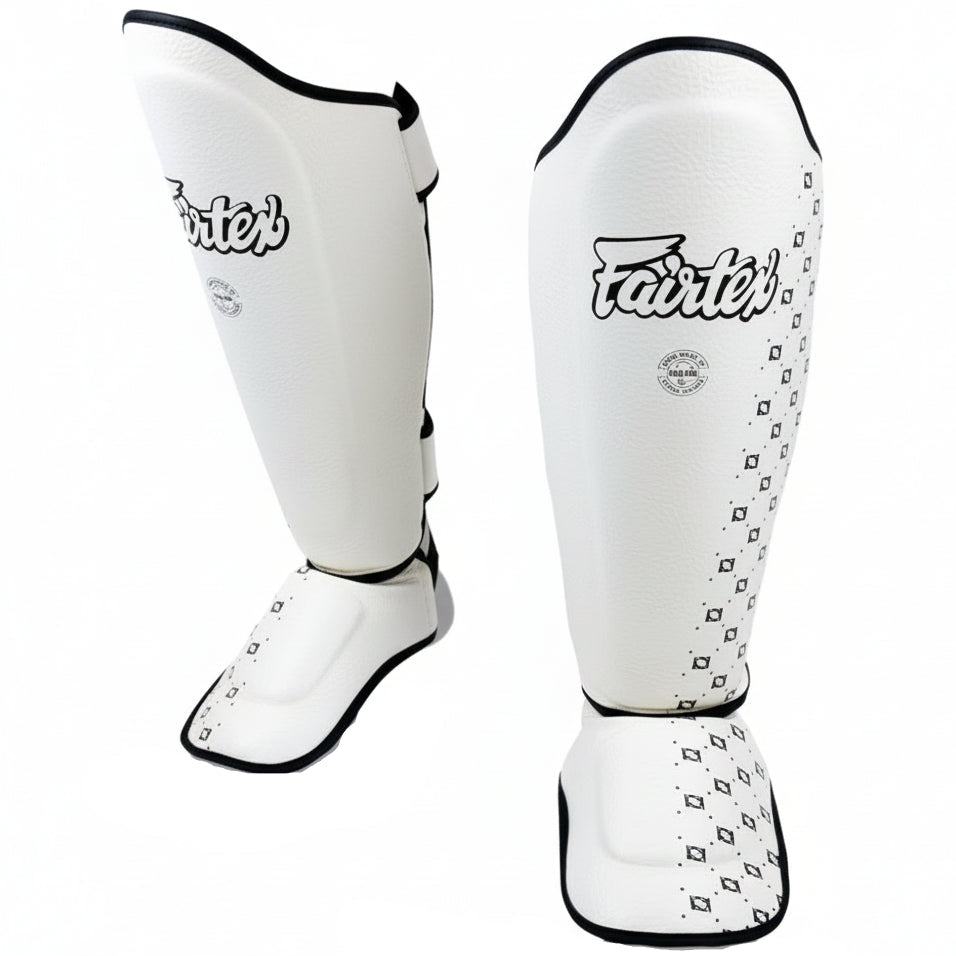 White shin guards with black accents on a white background, featuring the Fairtex brand.