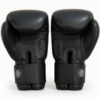 Pair of black boxing gloves on a light wooden surface