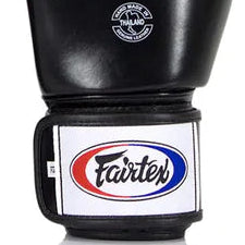 Pair of black boxing gloves with Fairtex logo on a white background