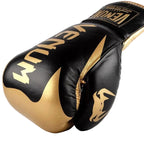 Black and gold boxing gloves with 'Venum' branding on a lightGold background