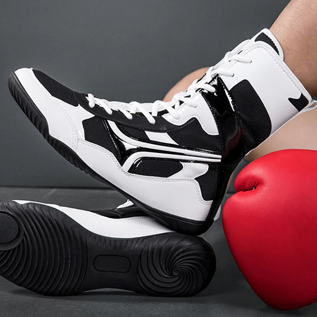Black and white high-top sneakers with red boxing glove on a dark background