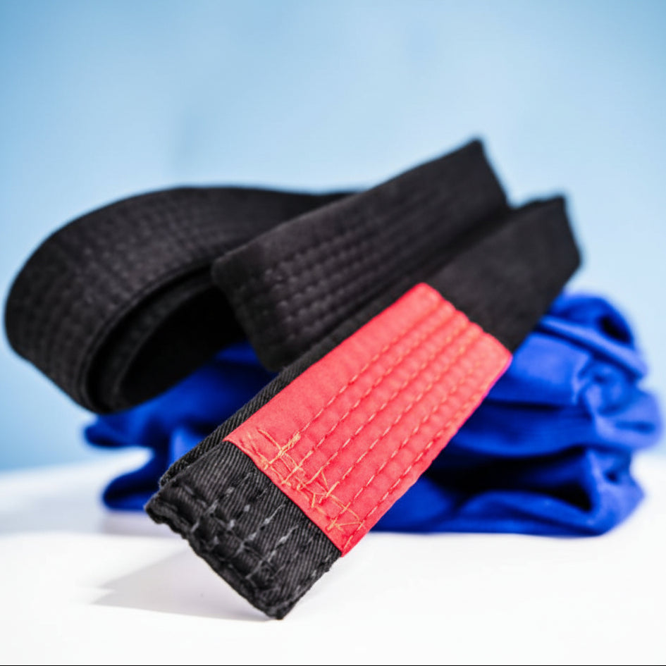 Black and red belt with blue fabric in the background