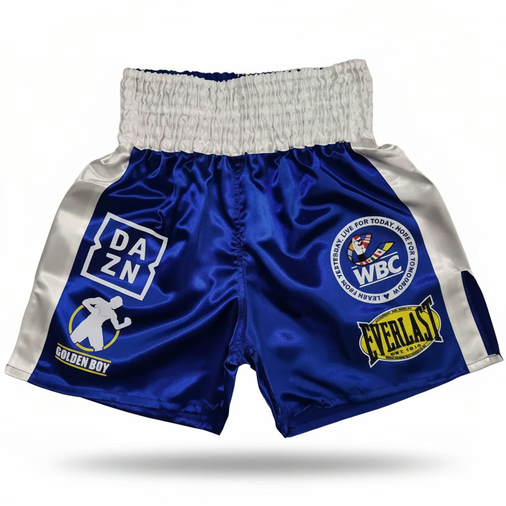 Blue and white boxing shorts with multiple brand patches including DAZN, WBC, and Everlast, displayed on a clean white background.