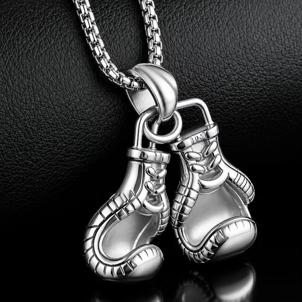 Silver boxing glove pendant on a chain against a dark background
