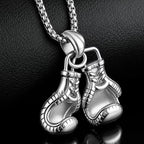 Silver boxing glove pendant on a chain against a dark background