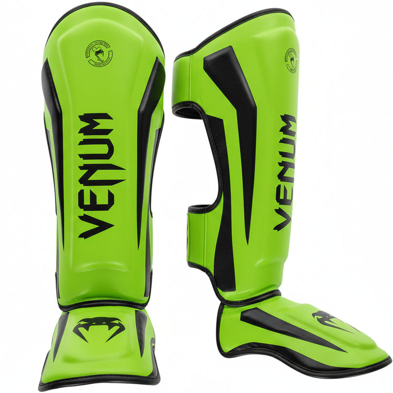 Bright green Venum shin guards on a gray background