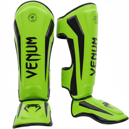 Bright green Venum shin guards on a gray background