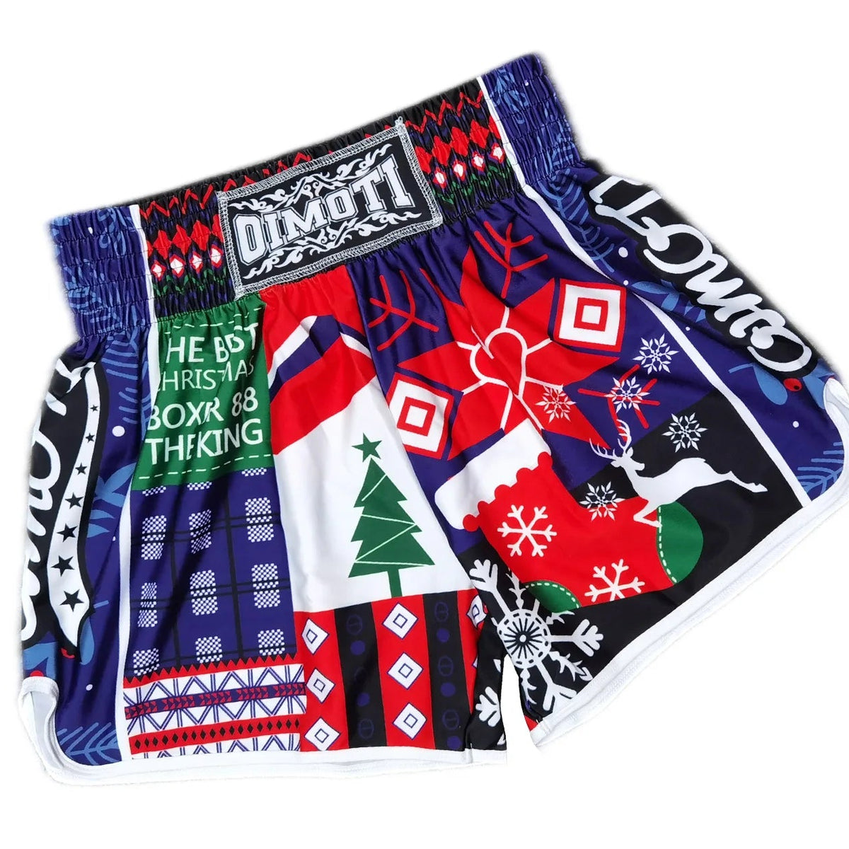 A pair of Oimoti athletic shorts featuring a vibrant, multi-colored Christmas-themed patchwork design with holiday patterns, set against a plain white background with a black promotional banner at the top.