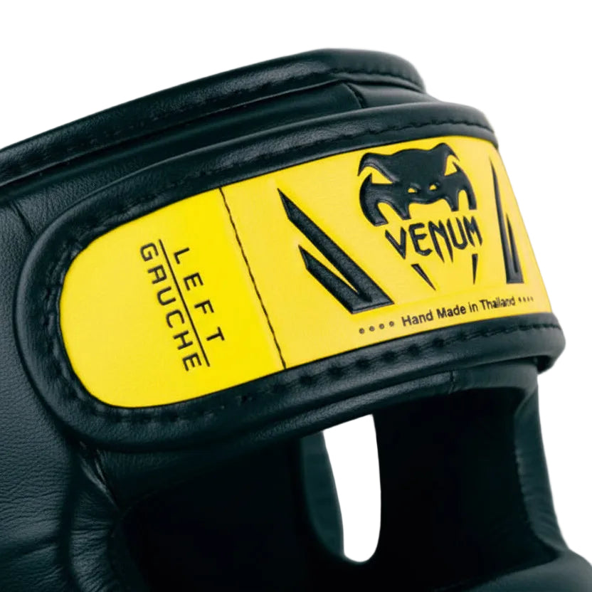 Black boxing glove with yellow label featuring Venum logo on a gray background