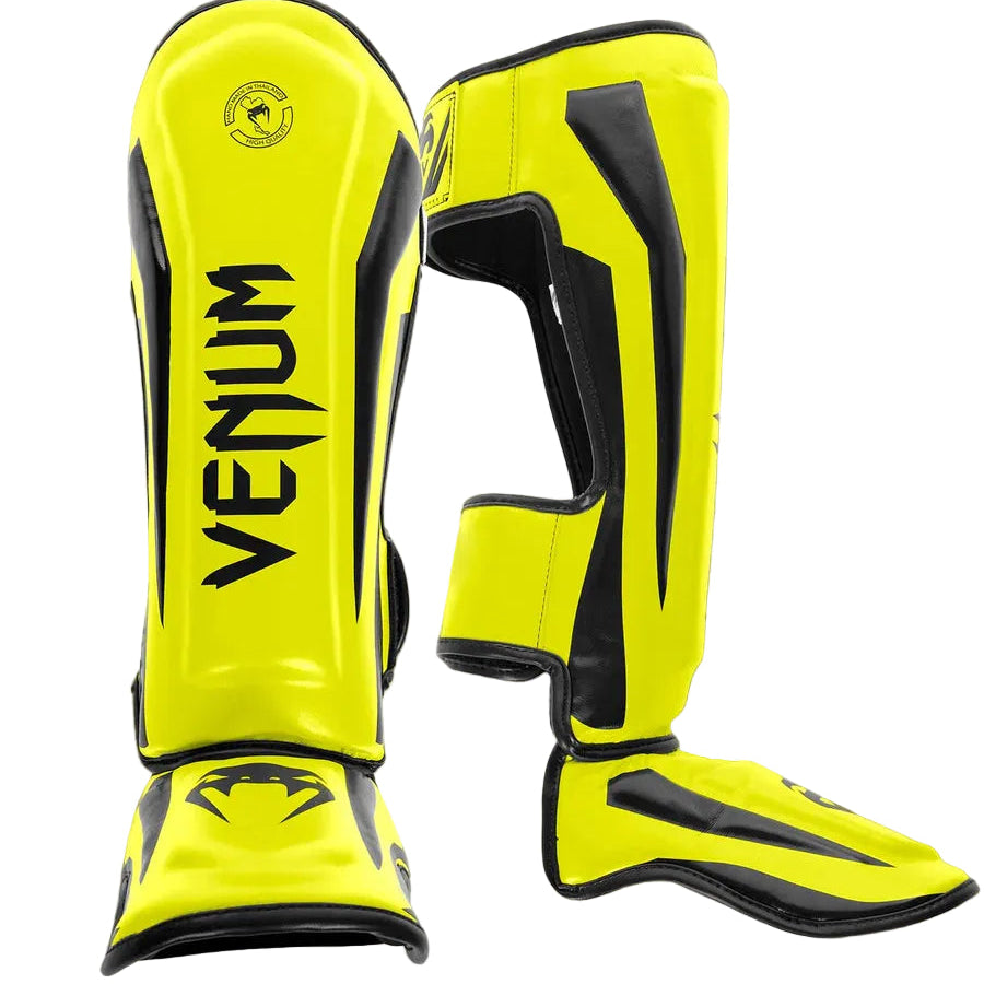 Yellow and black Venum shin guards on a gray background