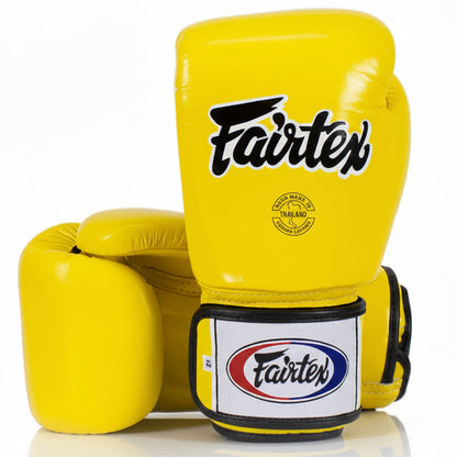 Yellow boxing gloves with Fairtex branding on a white background