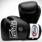 Black boxing gloves with Fairtex branding on a white background
