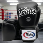 Black boxing gloves with Fairtex branding on a white background