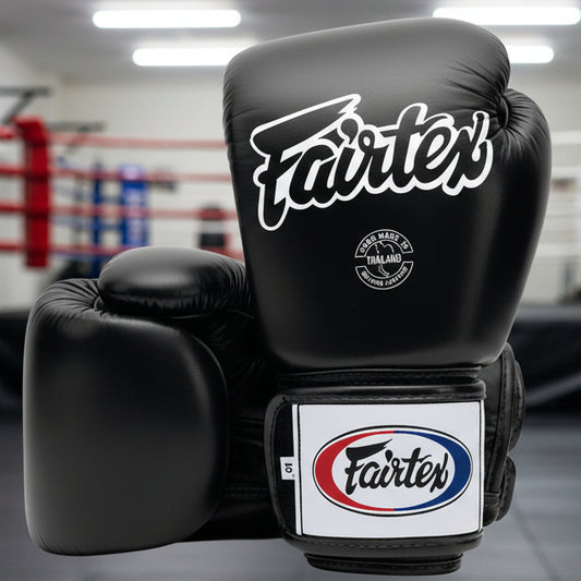 Black boxing gloves with Fairtex branding on a white background