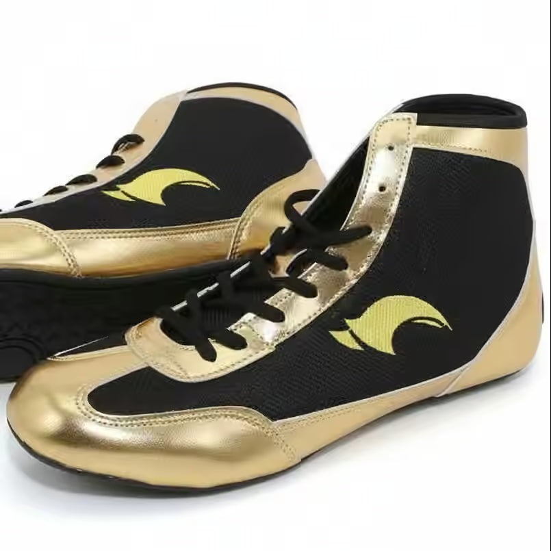 A pair of high-top athletic sneakers in black and metallic gold, featuring a black mesh upper, metallic gold toe and heel panels, black laces, and a gold wave-like logo on the side.
