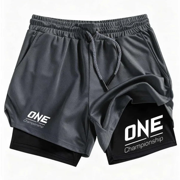 Black athletic shorts with a white 'ONE Championship' logo on the left leg and a black inner layer visible at the hem, shown on a plain white background.
