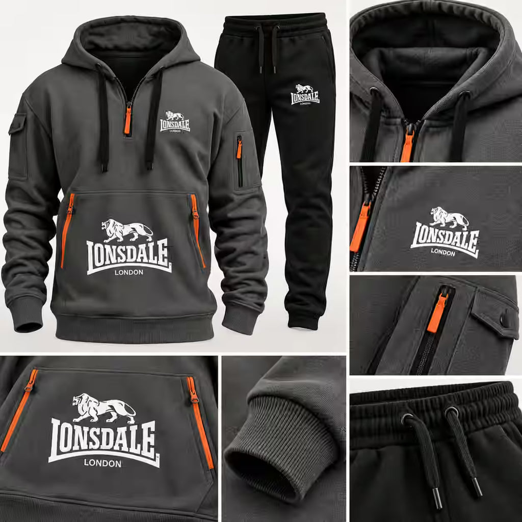 A dark gray and black Lonsdale hoodie with matching joggers, shown in a multi-view collage. The hoodie features a half-zip front, a large white Lonsdale London lion logo on the chest, and bright orange zipper accents.