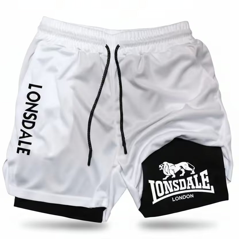White athletic shorts with black drawstrings, featuring 'LONSDALE' printed vertically on one leg and a black patch on the other leg with the Lonsdale London lion logo.