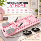 Pink full-body Pilates reformer exercise board with gray foot pads and black handles, shown in a bright home studio setting with text overlays and accessory handles nearby.