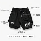 Black athletic shorts with white printed branding and feature callout labels on a light gray background. The shorts include drawstring, elastic waistband, compression support, and training fit details, with icons and text pointing to specific design features.