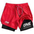 Red athletic shorts with a black inner layer visible at the hem, featuring white 'ONE Championship' logos on both legs and a gray-and-white drawstring, shown on a plain white background.