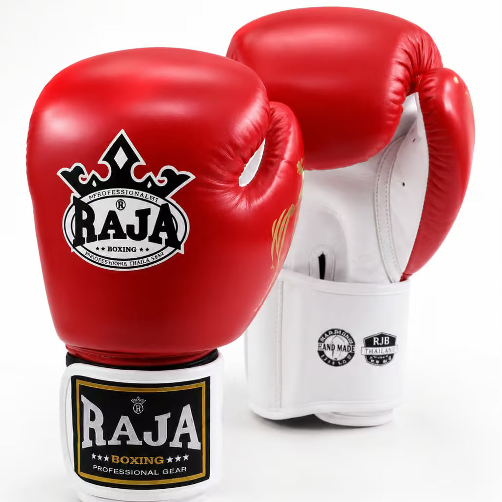 A pair of red and white boxing gloves from Raja Boxing, displayed on a clean white background. One glove is shown from the front, displaying the red leather exterior with the black and white 'RAJA BOXING' logo, while the other is shown from the back, displaying the white leather interior and wrist strap.