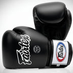 Black Fairtex boxing gloves on a light gray background