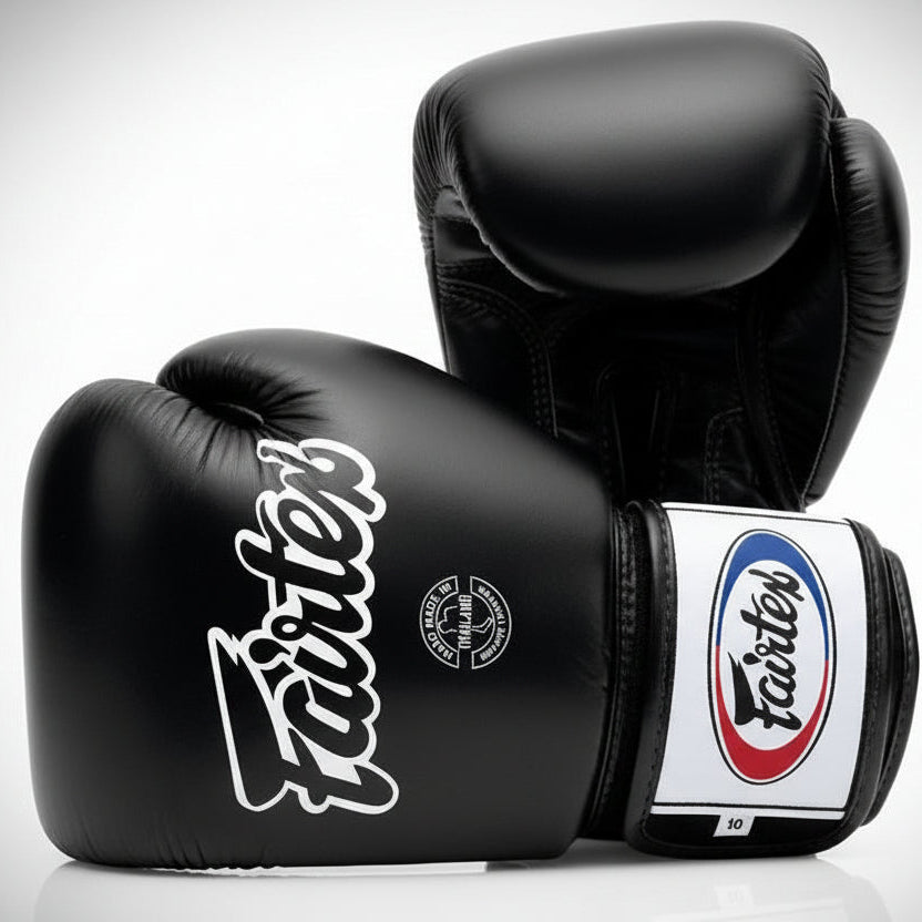 Black Fairtex boxing gloves on a light gray background
