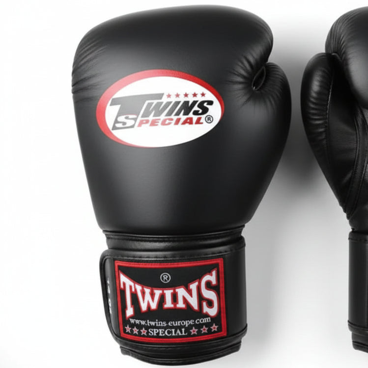 Black boxing gloves with Twins Special logo on a light gray background
