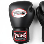 Black boxing gloves with Twins Special logo on a light gray background