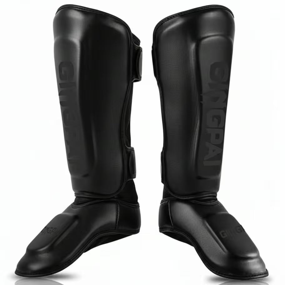 Pair of black shin guards with brand logo on a white background