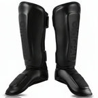 Pair of black shin guards with brand logo on a white background