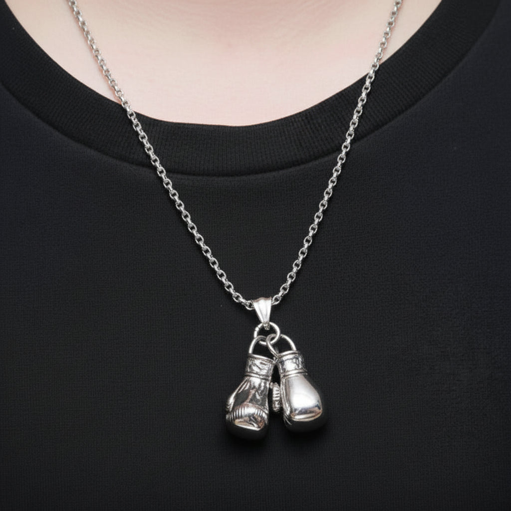 Silver necklace with boxing glove pendants on a black shirt