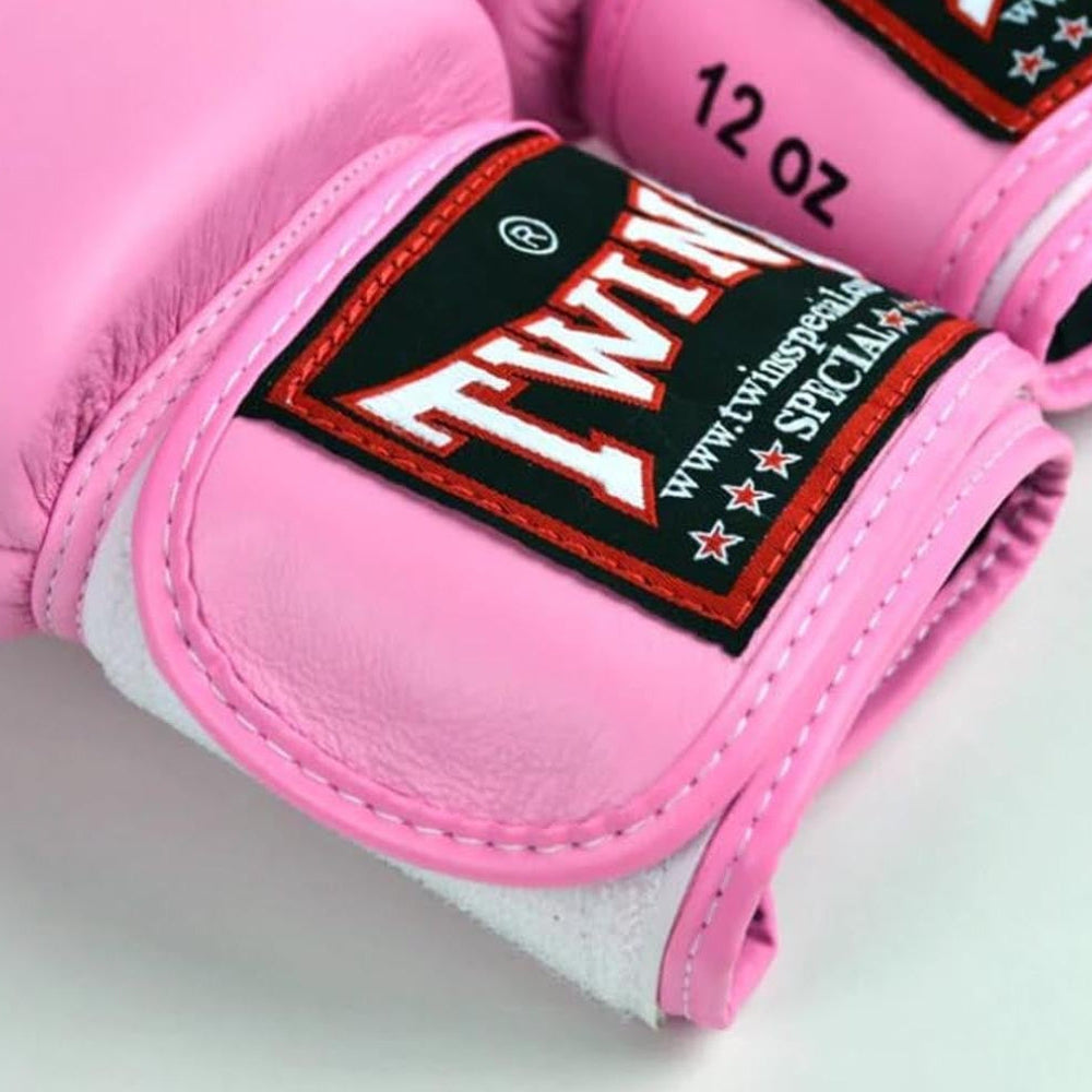Pink boxing gloves with a brand label on a light background